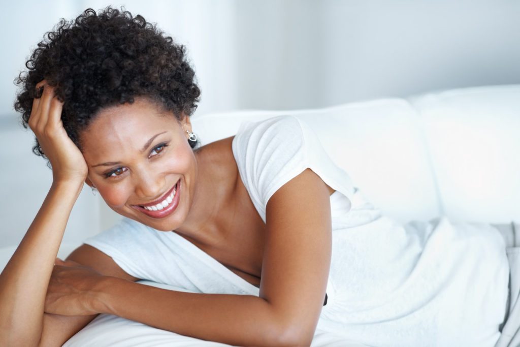 Smiling woman with natural hair relaxing