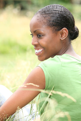 Woman in hair bun smiling in a field