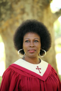 Black woman in red church robes outdoors portrait