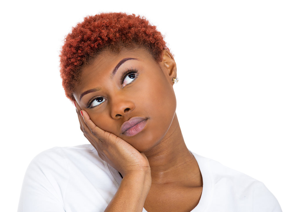 Woman with short colored natural hair looking thoughful