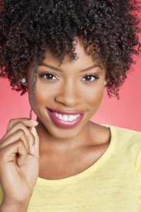 Black woman pulling a strand of her kinky curly hair