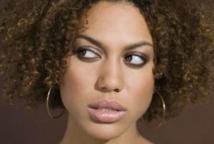 African American woman with curly hair looking confused