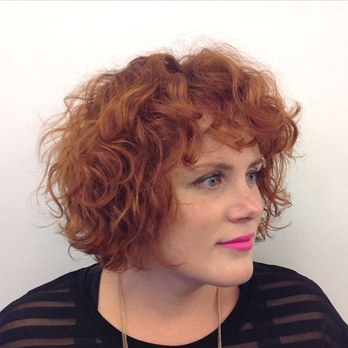 Short red curly hairstyle with bangs