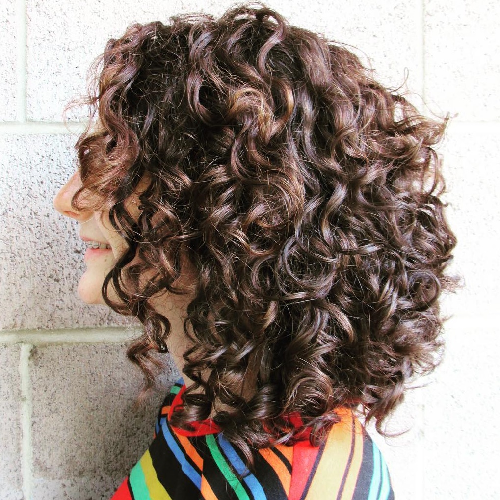 Medium Curly Brown Hairstyle with Subtle Highlights