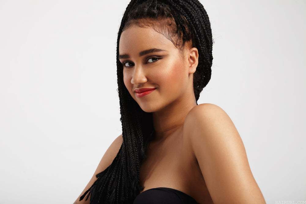 Poetic Justice Braids - Happy pretty black woman smiling with red lipstick.