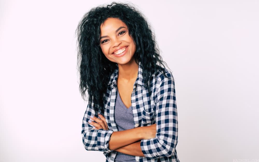 Black girl wearing a blue and white checkerboard shirt with human hair extensions
