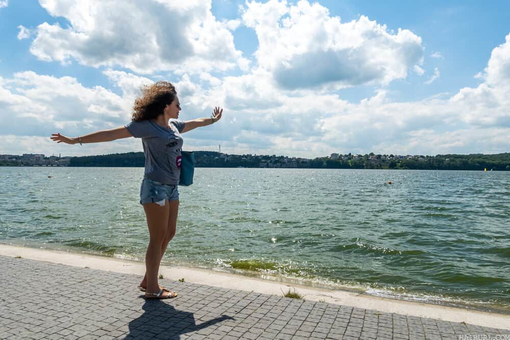 Lady dancing on a brick walkway at the lake as the brick fades into water.