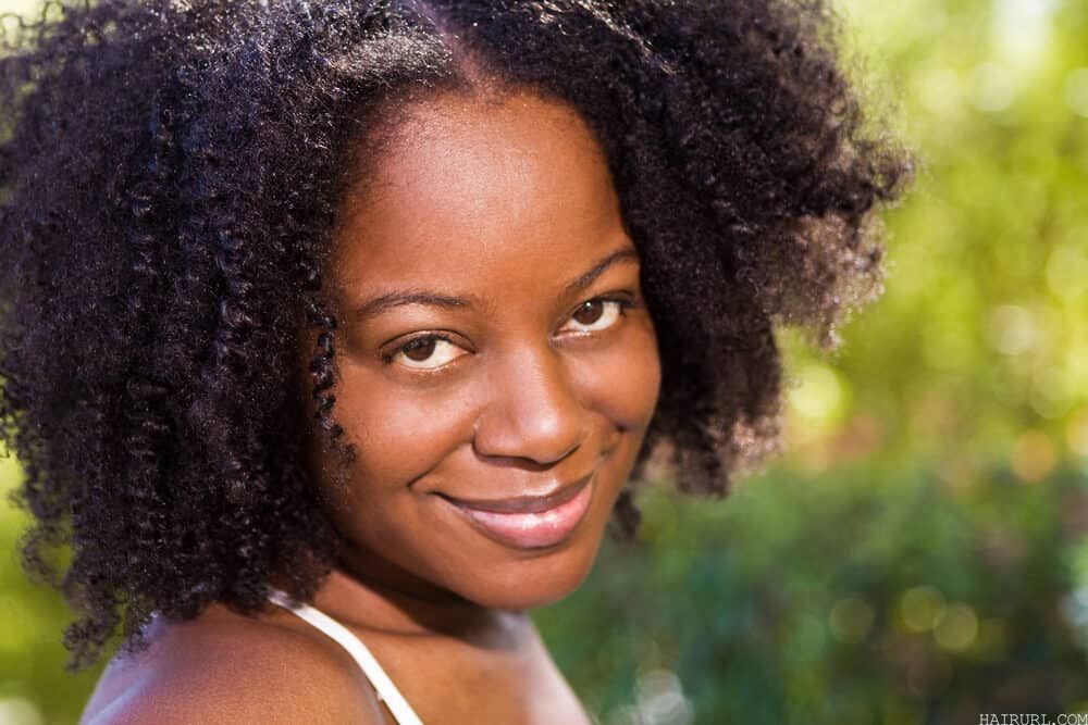 Mature black lady with a great smile with shiny strands treated with warm olive oil