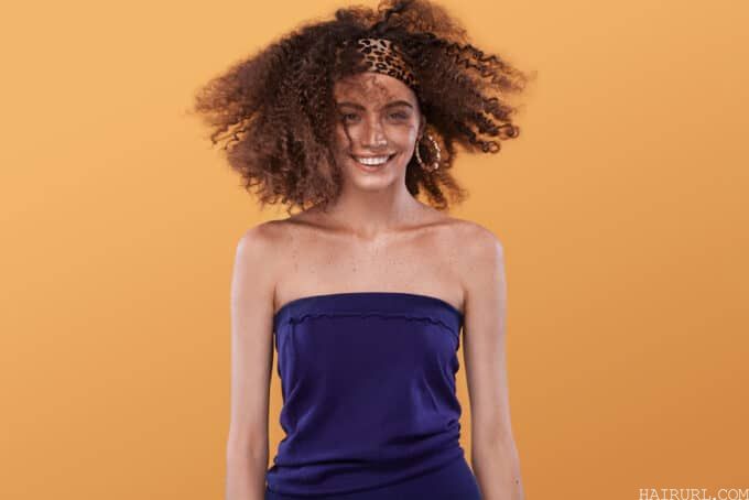 Beautiful young mixed race female wearing a blue dress with bouncy curls styled with texturizing spray